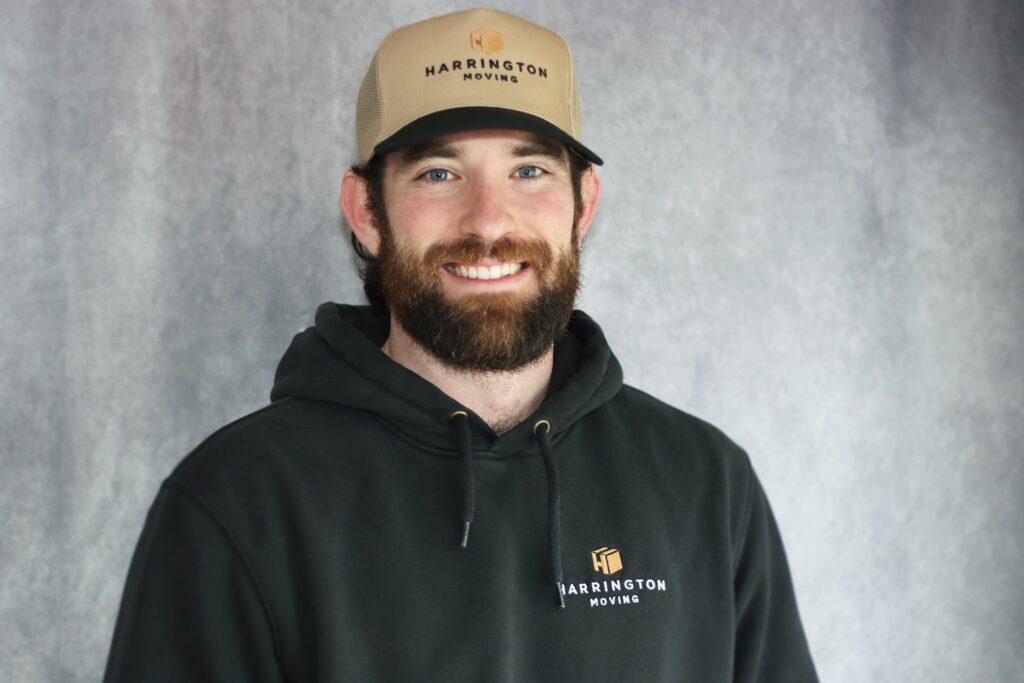 Dan Harrington, owner of Harrington Moving, wearing a Harrington Moving hat and hoodie
