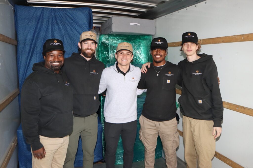 Harrington Moving team standing in a truck beside protected furniture